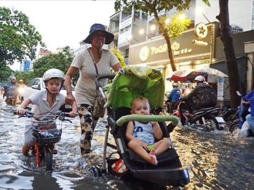 Người dân ở "khu nhà giàu" Thảo Điền bì bõm lội nước sau cơn mưa. Ảnh: M.Q 