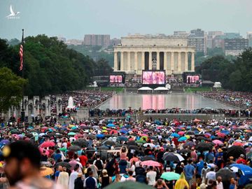 Người dân Mỹ đội ô xem tổng thống phát biểu. Ảnh: Reuters.