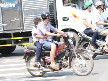 Các trường hợp chở trẻ em đầu trần đến trường sẽ bị phạt - Ảnh: MẬU TRƯỜNG