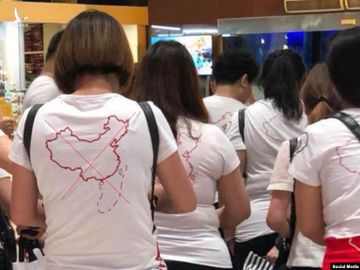 Du khách Trung Quốc mặc áo phông in hình đường lưỡi bò tại sân bay Cam Ranh. 
