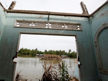 Một ngôi nhà đổ bên bờ sông Mekong ở thị trấn Mỏ Cày, tỉnh Bến Tre. Ảnh: Reuters.