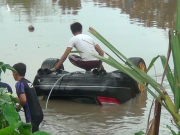 Chiếc ôtô được kéo vào sát bờ để cẩu lên khỏi mặt nước. Ảnh: Anh Minh. 