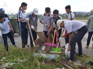 Các em học sinh đang dọn đống rác gồm nhiều mảnh thuỷ tinh vỡ. /// ẢNH: HOÀNG TRUNG