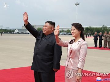 Ông Kim Jong-un và bà Ri Sol-ju vẫy chào Chủ tịch Trung Quốc Tập Cận Bình khi ông Tập rời Triều Tiên về nước vào ngày 21/6. Ảnh: Yonhap 