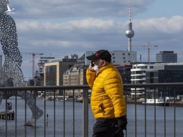 Người đàn ông đeo khẩu trang phòng dịch trên đường phố Berlin, Đức hôm 21/3. Ảnh: AFP.