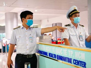 Cán bộ Trung tâm Kiểm dịch y tế quốc tế kiểm tra y tế đối với hành khách đáp xuống sân bay Tân Sơn Nhất /// Ảnh: Độc Lập