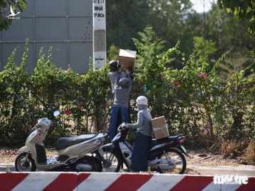 Người dân tìm cách ném hàng qua hàng rào bất chấp lệnh ngưng tiếp tế - Ảnh 3.