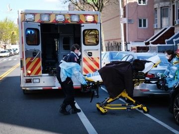 Nhân viên y tế di chuyển một bệnh nhân lên xe cứu thương ở New York ngày 11/4. Ảnh: AFP.