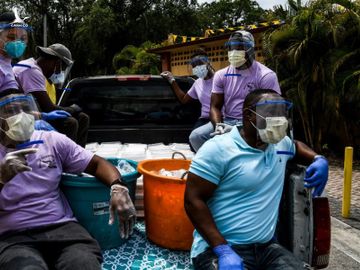 Tình nguyện viên phát thực phẩm cho người khó khăn tại bang Florida, Mỹ, hôm 11/4. Ảnh: AFP.