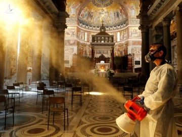 Người đàn ông khử trùng bên trong nhà thờ Trastevere Basilica ở Rome, Italy, ngày 11/5. Ảnh: Reuters.