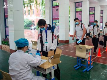 Học sinh xếp hàng chờ lấy mẫu sinh phẩm tại một trường học ở Vũ Hán hôm 14/5. Ảnh: AFP.