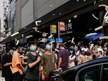 Người biểu tình tung tiền âm phủ trong cuộc tuần hành phản đối luật an ninh hôm 1/7. Ảnh: Reuters.