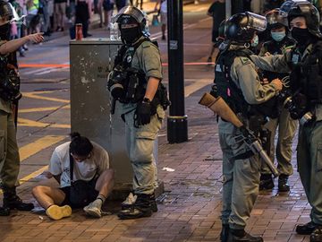 Cảnh sát Hong Kong bắt một người biểu tình (ngồi dưới đất), ngày 1/7. Ảnh: AFP.