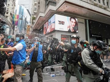 Một cảnh sát xịt hơi cay về phía phóng viên tác nghiệp ở Vịnh Causeway hôm nay. Ảnh: SCMP.