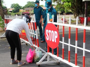 Tiếp tế lương thực, thực phẩm cho những người thân trong khu cách ly /// ẢNH: MẠNH CƯỜNG