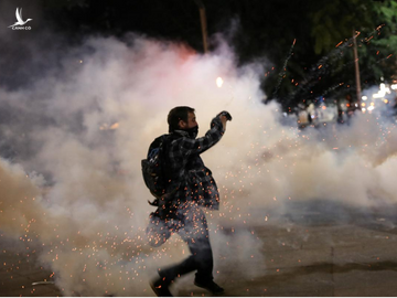 Một người biểu tình ném trả lựu đạn cay về phía cảnh sát tại TP.Portland, bang Oregon /// Reuters