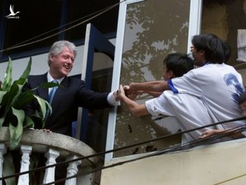 Tổng thống Mỹ Bill Clinton (trái) bắt tay người dân Việt Nam từ ban công một tòa nhà đối diện Văn Miếu - Quốc Tử Giám, Hà Nội tháng 11/2000. Ảnh: AP.