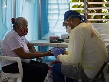 Y tá lấy mẫu máu của người phụ nữ tại El Salvador ngày 30/7. Ảnh: AFP.