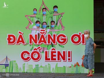 Một người dân đi ngang qua tấm pano trên đường Lê Duẩn (Đà Nẵng), chiều 7/8. Ảnh: Nguyễn Đông.