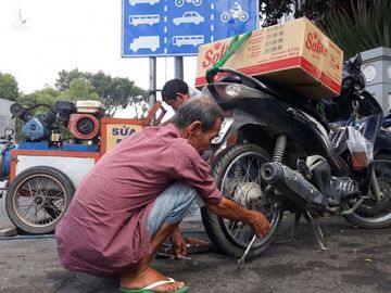 Người đàn ông lớn tuổi phá ruột xe tại điểm vá xe ở góc đường Lê Duẩn - Tôn Đức Thắng (Q.1) /// ẢNH: TRẦN TIẾN