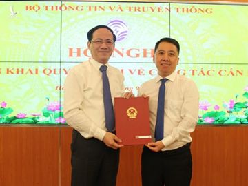 Thứ trưởng Bộ Thông tin Truyền thông Phạm Anh Tuấn trao quyết định cho ông Lã Hoàng Trung (phải). Ảnh: MIC