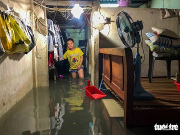 Sau cơn mưa cả tiếng ở TP.HCM, nước tràn vào nhà dân gần 1m - Ảnh 2.