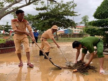 Công an, bộ đội giúp người dân dọn bùn sau lũ lụt ở Quảng Bình