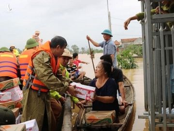 Người dân lội nước ngập sát cổ đi nhận hàng cứu trợ ở Quảng Bình