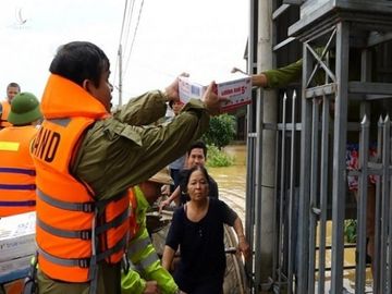 Người dân lội nước ngập sát cổ đi nhận hàng cứu trợ ở Quảng Bình