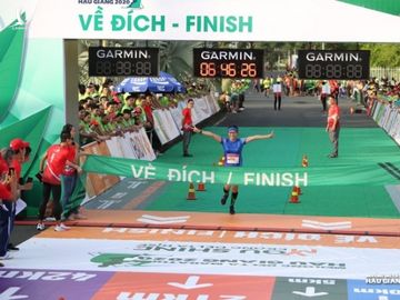 Các VĐV chúc mừng ông Đoàn Ngọc Hải về đích tại giải marathon Hậu Giang - 1