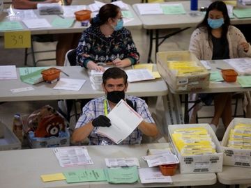 Các nhân viên kiểm tra hàng ngàn lá phiếu gửi qua thư ở bang California ngày 2.11 /// Reuters