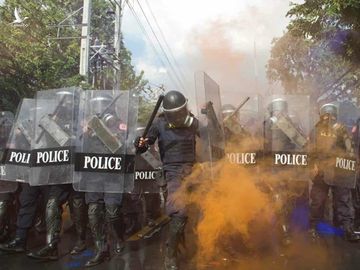 Cảnh sát Thái Lan bị người biểu tình ném bom khói màu tại thủ đô Bangkok hôm 17/11. Ảnh: AFP.