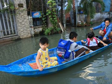 Dù ở trong phố nhưng người dân vẫn phải chèo xuồng đưa con đi học /// Ảnh: Lê Ngọc Thảo