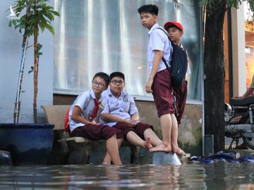 Người dân TP.HCM chèo xuồng đưa con đi học trong phố vì ngập mãi không hết - ảnh 9