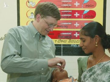 Bill Gates cho một em bé uống vaccine phòng bại liệt năm 2002 tại Ấn Độ. Ảnh: Jeff Christensen