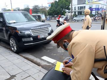 Cảnh sát ghi thông báo phạt nguội với xe ôtô vi phạm trên đường Giải Phóng, Hoàng Mai vào sáng 15/12. Ảnh: Phương Sơn