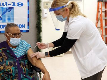 Nhân viên y tế tiêm vaccine Covid-19 cho một người cao tuổi ở Brooklyn, New York hồi cuối tháng 12/2020. Ảnh: Reuters.