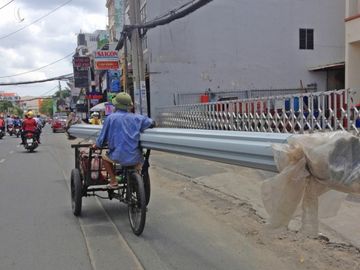 Người đàn ông chạy xe ga gác chở tôn cồng kềnh trên đường Phan Văn Trị, quận Gò Vấp, năm 2020. Ảnh: Gia Minh.