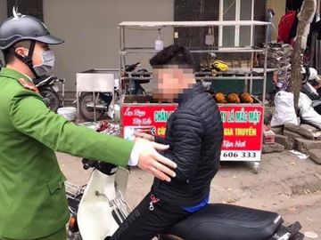 Cảnh sát ra quân xử phạt người không đeo khẩu trang. Ảnh: Phạm Dũng.