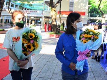 2 nữ tân binh TP.HCM nhận hoa chúc mừng trước giờ lên đường nhập ngũ. /// Ảnh: Nguyên Vũ