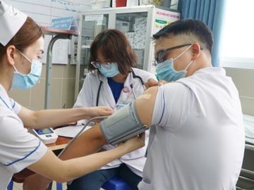 Điều dưỡng Thoại cười tươi khi đo sinh hiệu lần thứ 4 trong 30 phút sau tiêm. Ảnh: Thư Anh.