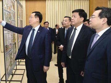 Bí thư Thành uỷ Hà Nội Vương Đình Huệ cùng các đại biểu thăm quan phòng trưng bày đồ án sáng 22/3. Ảnh: Viết Thành