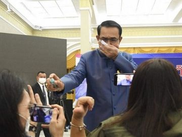 Thủ tướng Prayut Chan-o-cha phun nước rửa tay vào mặt phóng viên trong cuộc họp báo ngày 9-3. Ảnh: HAYAT