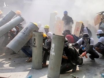 Người biểu tình che chắn khi đụng độ với cảnh sát ở Yangon, Myanmar, ngày 28/2. Ảnh: Reuters.