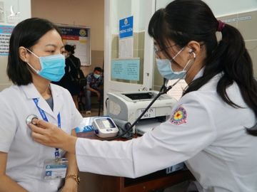 Dược sĩ Bích Hồng được đo nhịp tim và khai thác tiền sử dịch tễ trước khi tiêm vaccine Covid-19. Ảnh: Thư Anh.