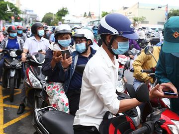 Lực lượng chức năng hướng dẫn người dân khai báo y tế tại chốt trạm Phan Văn Trị (TP.HCM) trong những ngày giãn cách.