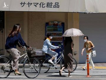 Người Nhật Bản đạp xe tại quận Shinagawa, Tokyo, ngày 19/7. Ảnh: AFP