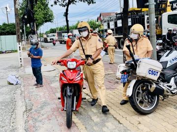 Lực lượng CSGT kiểm tra, xử lý người ra đường có lý do chính đáng hay không. /// Ảnh: ĐỖ TRƯỜNG