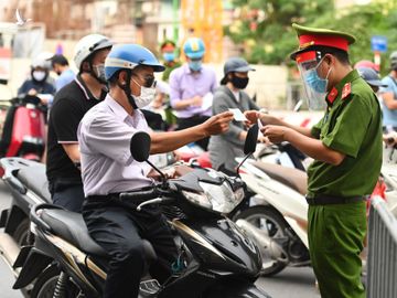 Lực lượng công an kiểm tra giấy điều kiện lưu thông của người tham gia giao thông tại phố Phạm Ngọc Thạch, ngày 28/7. Ảnh: Giang Huy.