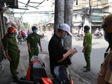 Cảnh sát kiểm tra người vi phạm phòng dịch ở quận Gò Vấp, sáng 14/7. Ảnh: Đình Văn.